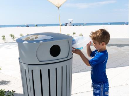 Young boy cleaning trash off the beach