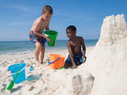 Kids building sandcastles on Alabama's beaches