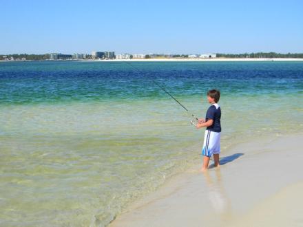 Kid surf fishing on the beach in Orange Beach