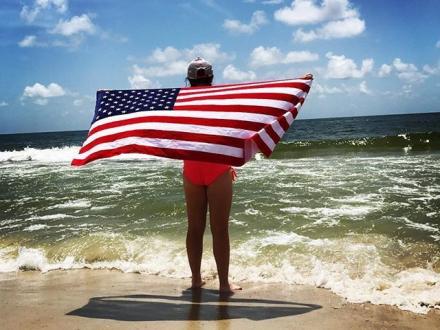 Girl with American flag on the beach
