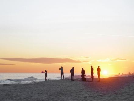 Family on the beach watching at the sunset in Orange Beach
