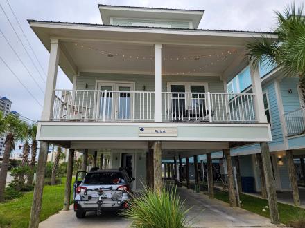 Elevated beach house rental in Gulf Shores, Alabama, with spacious porch and covered parking