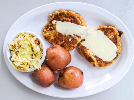a plate of crab cakes, potatoes, and Cole slaw from Hammered Crab in Gulf Shores