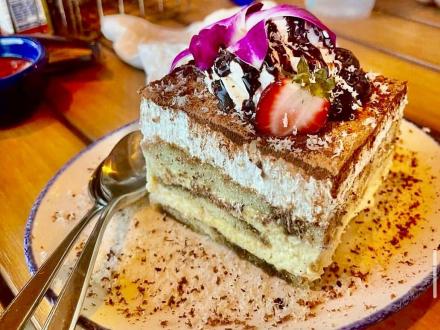 Bushwacker tiramisu from CoastAL Orange Beach, layered with rich flavors and topped with fresh fruit