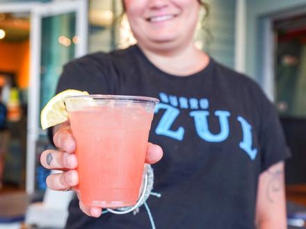 Waitress holding a pink cocktail at Burro Azul Mexican restaurant in Gulf Shores.