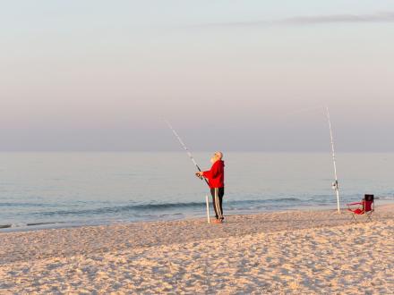 Angler surf fishing at sunrise on Alabama's Beaches