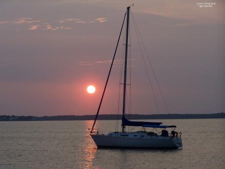 Boat sailing in the Gulf of Mexico at sunrise, best sunrise cruises in Orange Beach