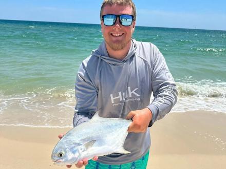 Angler holding a pompano caught along the surf in Gulf Shores.