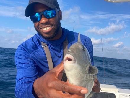 Angler holding a triggerfish caught on a fishing charter caught in the Gulf of Mexico