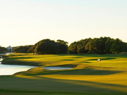 Aerial view of the greens at Kiva Dunes Golf Resort at sunset