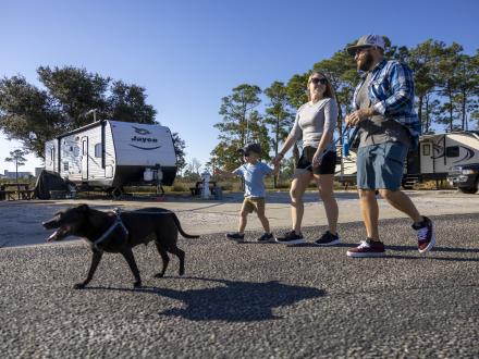 A family enjoying their RV park rental with their pet on an Alabama's Beaches vacation