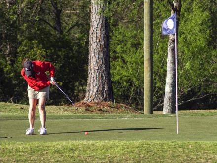Women putting a golf ball at One Club Club Golf course
