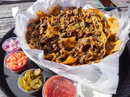 a huge plate of spicy crawfish nachos at Pink Pony Pub beachfront bar in Gulf Shores