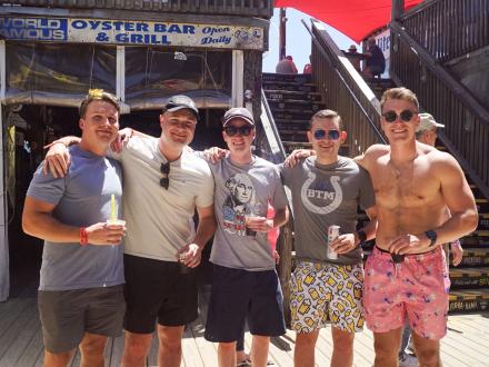 A group of guys with drinks at the legendary Flora-Bama Lounge in Orange Beach