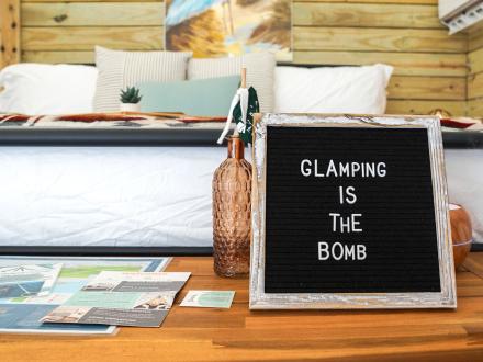 sign that says "Glamping is the bomb" at a Timberline Glamping tent in Orange Beach
