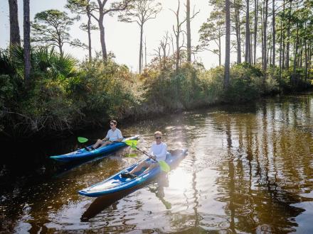Two guys kayaking in the backbays of Orange Beach