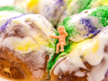 Plastic baby on a traditional iced king cake for mardi gras