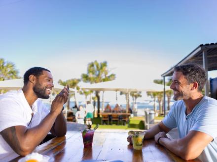 Two guys enjoying drinks at The Gulf beachfront restaurant in Orange Beach