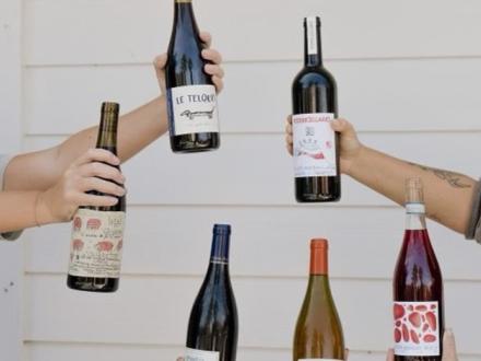 Hands holding bottles of wine at Isla Wine in Gulf Shores