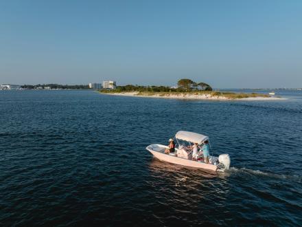 Rose boat cruising in the blue waters near Robinson Island in Orange Beach