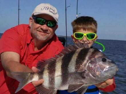 Man and boy holding a sheepshead caught on a fishing trip in the Gulf off Orange Beach