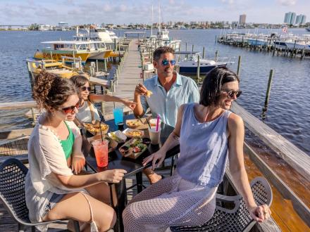 Family eating outdoor by the water at Avenue Pub in Orange Beach
