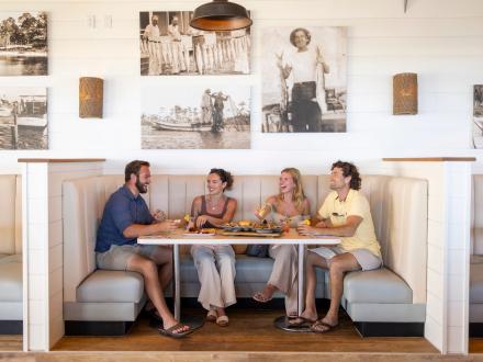 Friends dining at a booth inside Coastal beachfront restaurant in Orange Beach