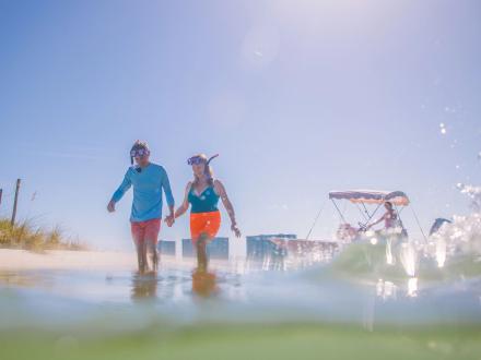 Couple walking in the water near the islands with snorkels