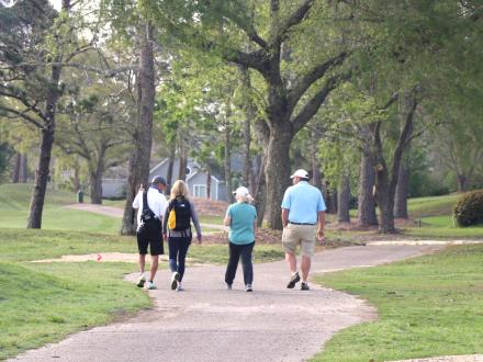 Family walking along Craft Farms golf course in Gulf Shores
