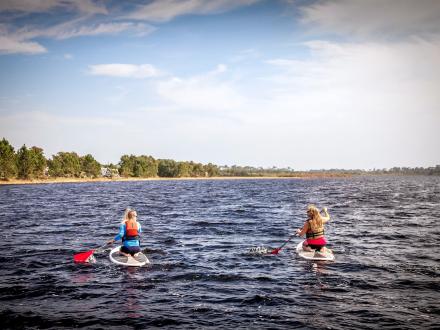 Two women paddle boarding in Lake Shelby