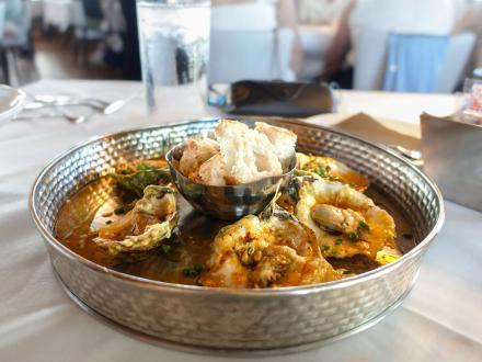 a half dozen baked oysters served with bread at Jesse's on the Bay fine dining restaurant in Fort Morgan