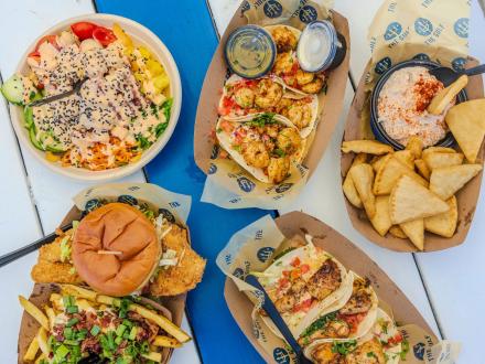 a picnic table filled with delicious food at The Gulf open-air restaurant in Orange Beach