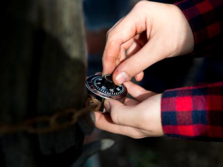 Hands unlocking a safe in an escape room