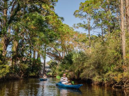 Family kayaking along the back bay waterways in Orange Beach