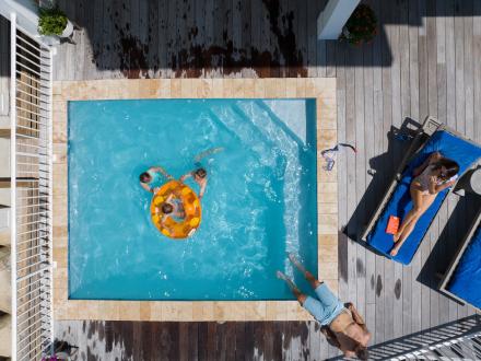 Aerial shot of a family playing in a pool at their beach house in Orange Beach