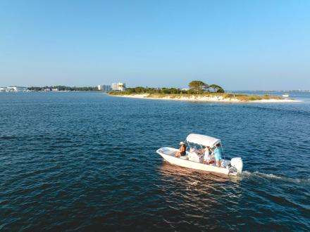 Rosè boat cruising in the water near the islands in Orange Beach