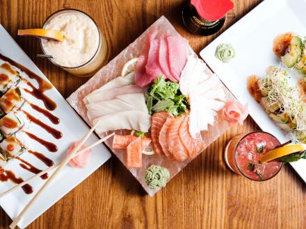 overhead shot of fresh sushi and cocktails on a table at Stephi Cocktails & Cuisine in Orange Beach