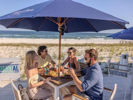 People dining outdoors at Coastal Restaurant, beachfront dining in Orange Beach