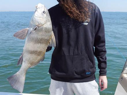 Man holding a black drum caught in the Gulf off of Gulf Shores