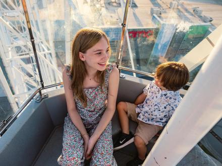 A girl and little boy riding the Ferris wheel at The Wharf