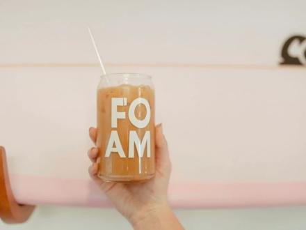 Hand holding up a glass of iced coffee at Foam Coffee shop in Gulf Shores