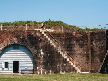 Woman climbing down the stairs at Historic Fort Morgan