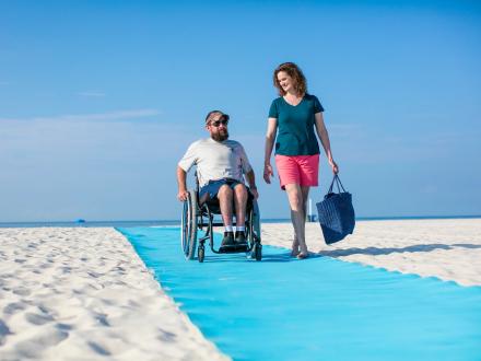 Woman and man using the accessible beach mats in Gulf Shores