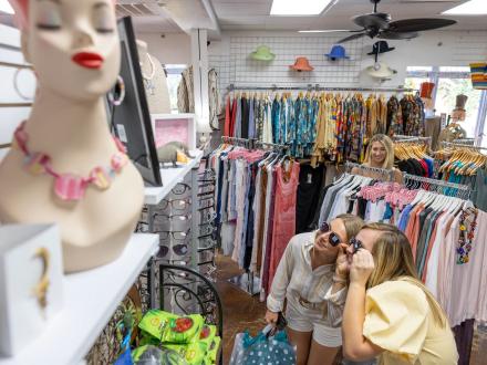 Girls trying on sunglasses at a local boutique at San Roc Cay shopping center in Orange Beach