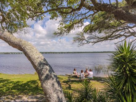 a group sitting around a picnic table at Lake Shelby in Gulf State Park