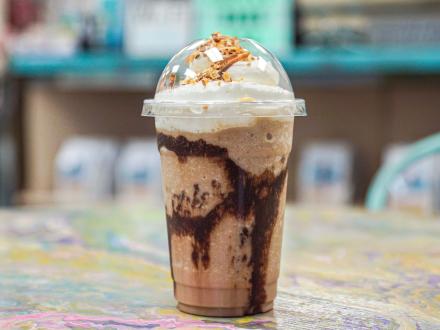 a to-go cup of a bushwacker frappe with whipped cream at Southern Shores Coffee Shop