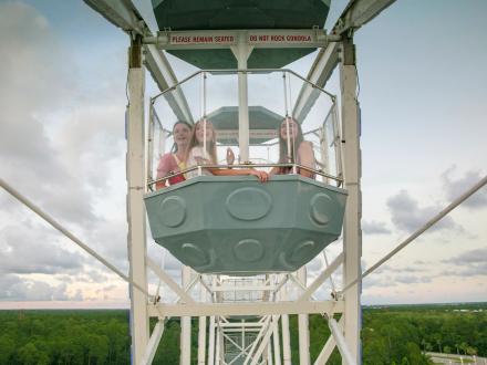 Teenage girls at the top of the Ferris wheel at The Wharf in Orange Beach