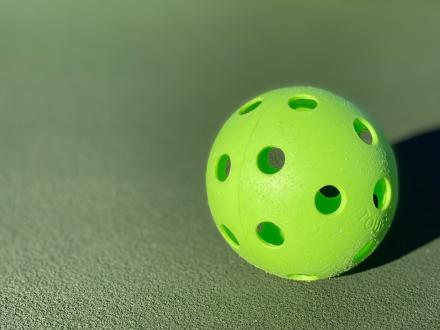 lime green pickleball on a court