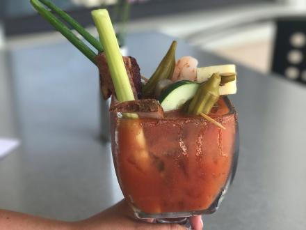 a Bloody Mary filled with veggies and meats at Brick and Spoon brunch restaurant in Orange Beach