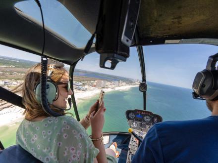 woman taking a helicopter ride over the beach with Lost Bay Helicopters in Gulf Shores